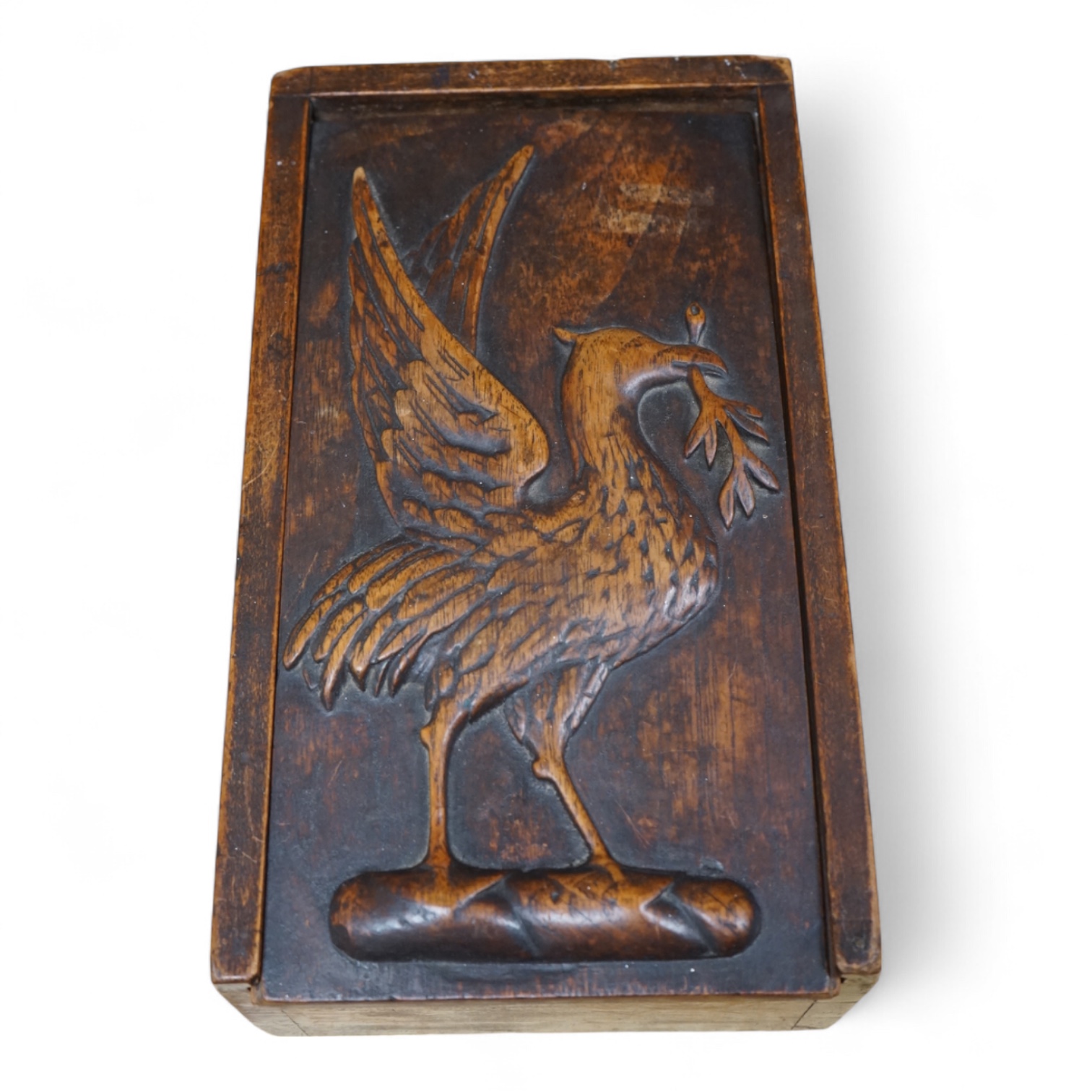 A 19th century games box with sliding cover carved with an eagle. The box containing a part bone stained chess set, box 28cm deep